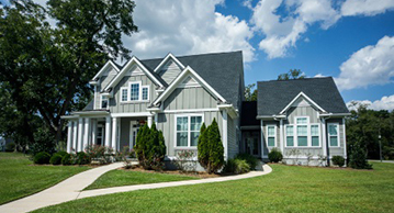 Stick built two story house with siding and breezeway.