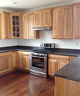 wood cabinet and dark kitchen countertop photo